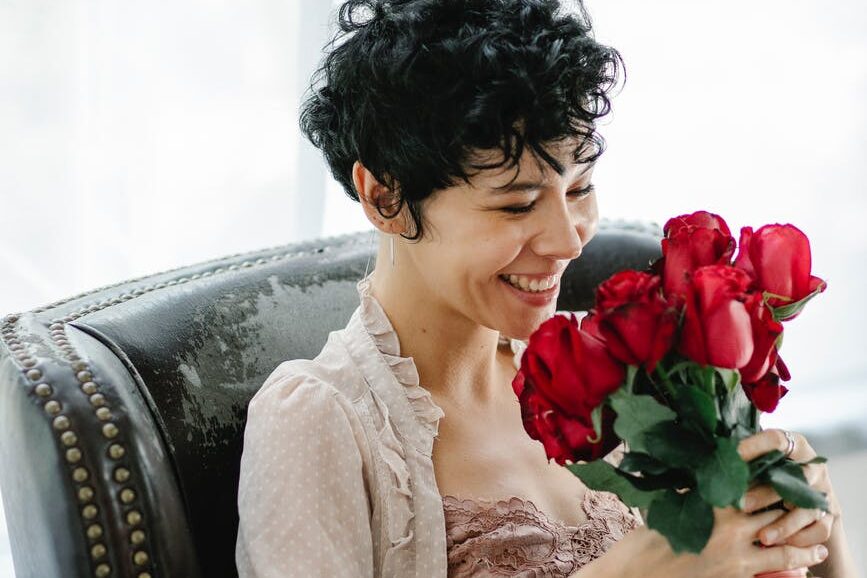 smiling woman with bouquet of roses imposter syndrome