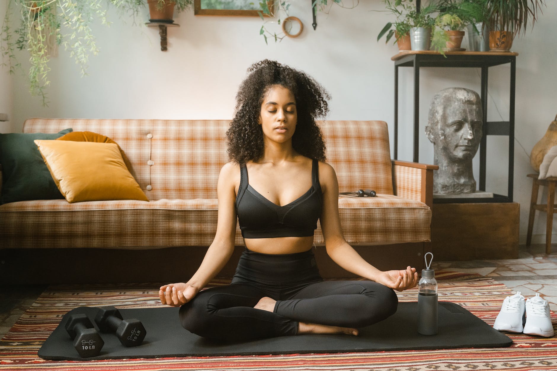 woman in black activewear meditating indoors