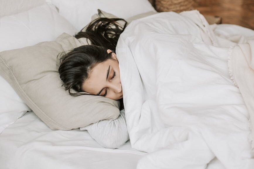 woman sleeping on a bed with white blanket